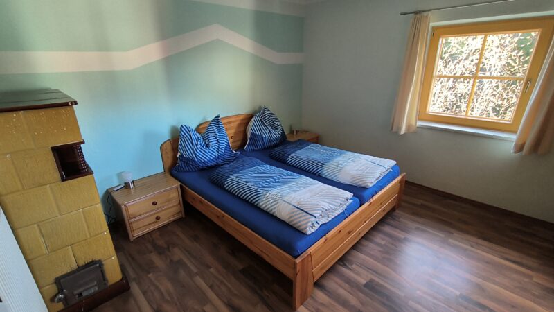 Schlafzimmer mit stilvoller Einrichtung und Blick auf die malerische Landschaft der Wimitzer Berge in Kärnten.